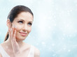© Karramba Production - Woman applying cream on her face, winter background