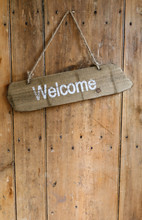 Welcome Sign Hanging From A Nail On An Old Rustic Wooden Oak Wea