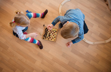 Wall Mural - Brother and sister playing with chess