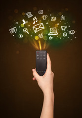 Hand with remote control and social media icons