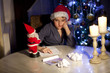 © Denizo - little boy writing wish list at home in the living room