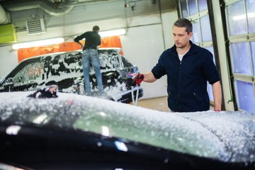 Poster - Man worker washing luxury car on a car wash