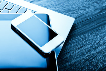 keyboard with phone and tablet pc on wooden desk