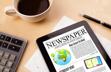 Wall Mural - tablet pc shows news on screen with a cup of coffee on a desk