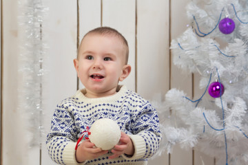 Baby boy under Christmas fir tree