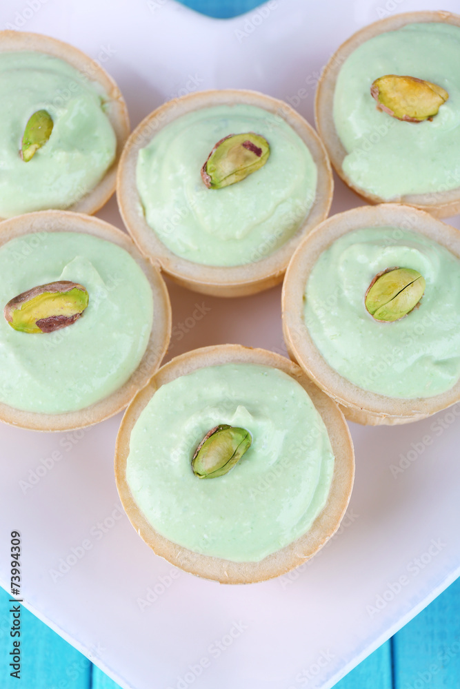 Tartlets with greens and sauce on plate close-up