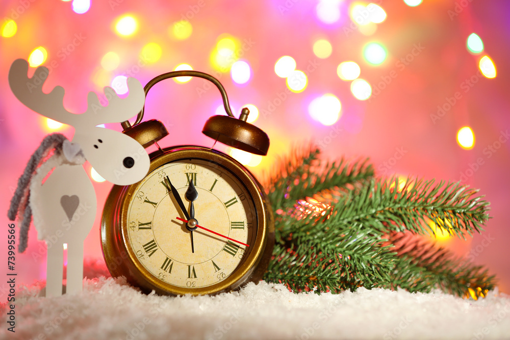 Alarm clock and Christmas decorations in snow