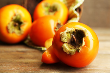 Ripe persimmons on wooden background