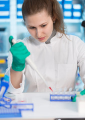 Sticker - Female laboratory assistant with a pipette in a scientific labor