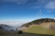 Wind Power Mills Above Fog In Black Forest, Germany
