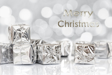 Wall Mural - Merry Christmas gifts in shiny paper, bokeh lights background