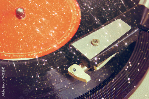 Poster top view of record over textured background with glitter light .