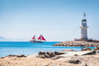 Lighthouse and tourist yacht by the sea
