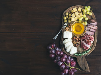 Wine appetizers set: meat and cheese selection, honey, grapes, w