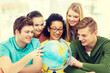 © Syda Productions - five smiling student looking at globe at school