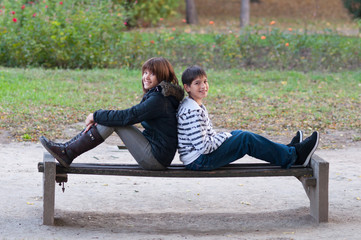 Wall Mural - Teenage boy and girl having fun in the park on beautiful autumn