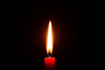 Red candle burning on a black background