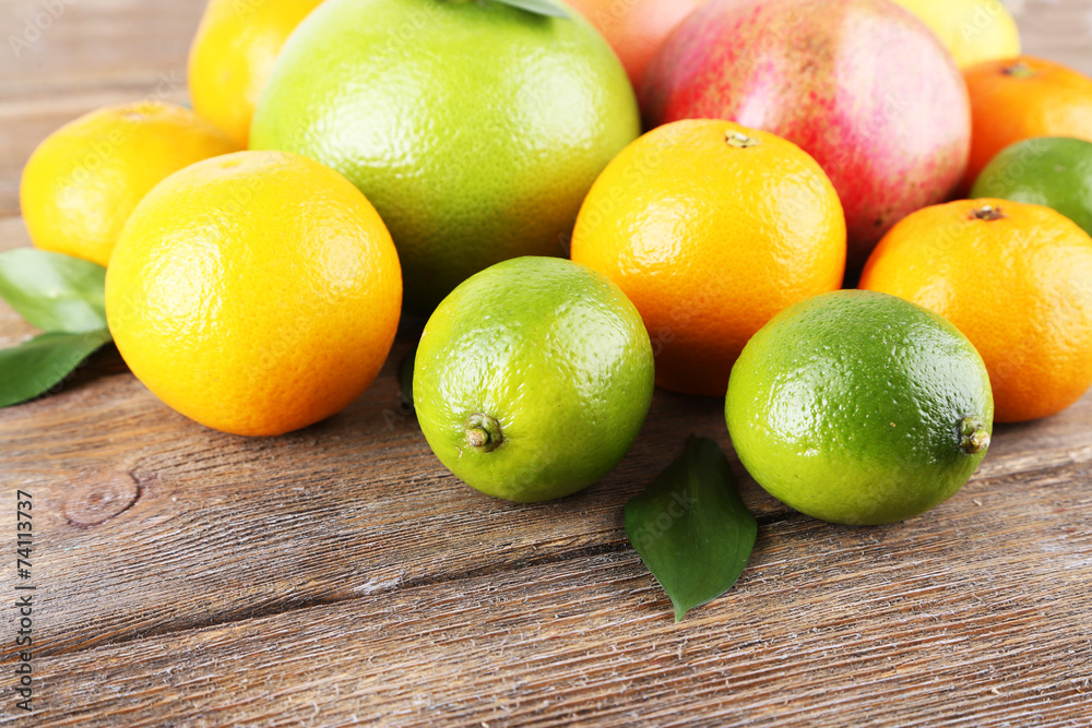 Ripe citrus with green leaves on wooden background