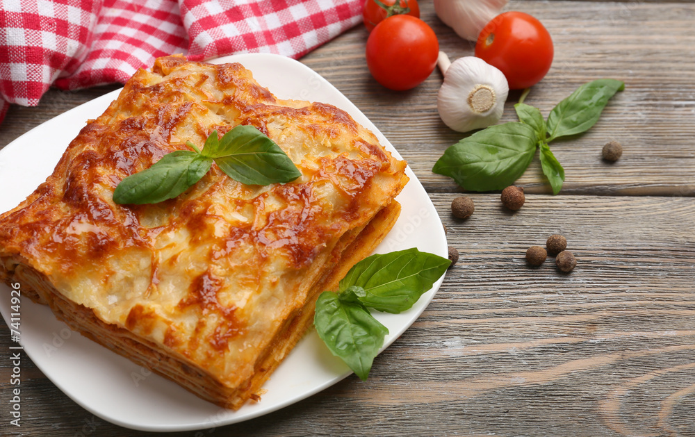 Portion of tasty lasagna on wooden table