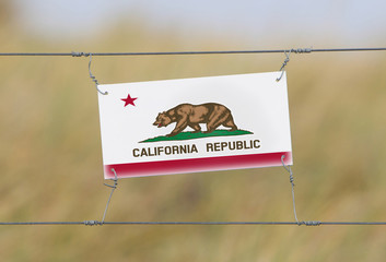 Border fence - Old plastic sign with a flag