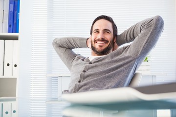 Relaxed casual businessman leaning back at his desk