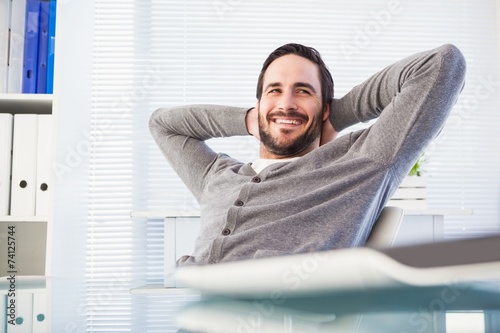 Fotografía Relaxed casual businessman leaning back at his desk