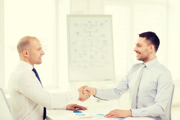 Sticker - two smiling businessmen shaking hands in office