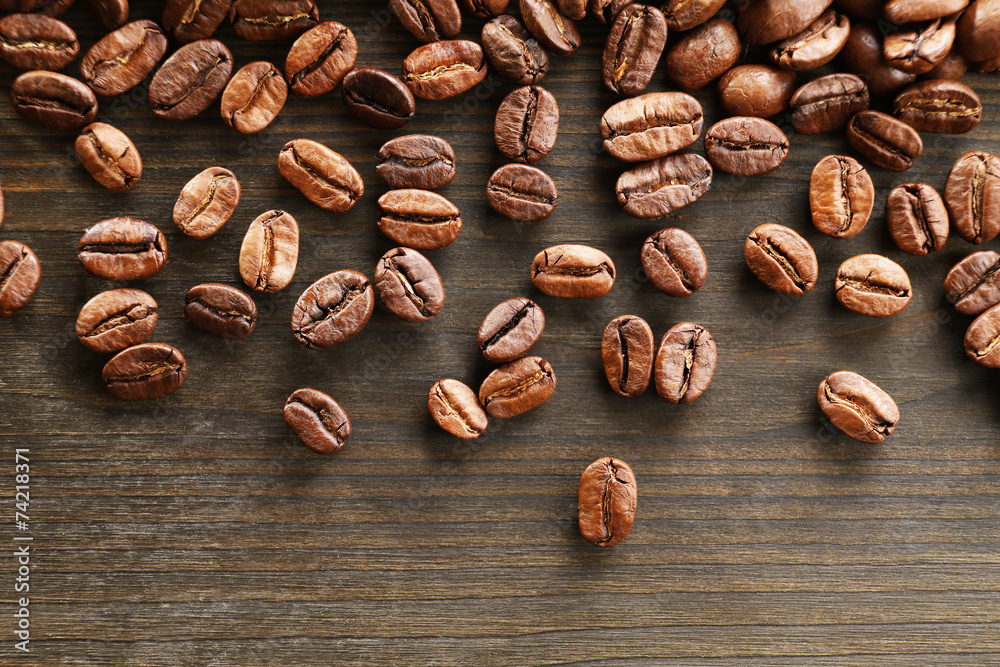 Coffee beans on wooden background, close-up