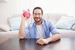 © WavebreakMediaMicro - Happy man shaking a pink piggy bank
