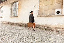 Woman Walking On The Street Porphyry With Suitcases