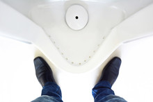 Top View Of A Man Legs In Front Of Urinal In Men Toilet