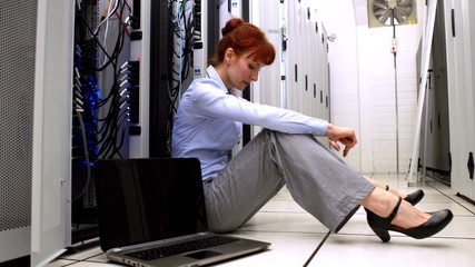 Poster - Stressed technician sitting on floor beside open server