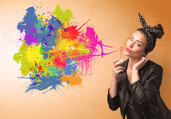 Cute girl blowing colorful splash graffiti