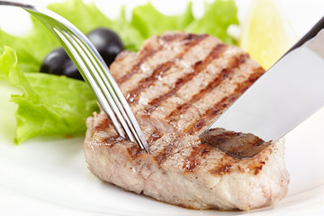 Grilled steak on white plate closeup