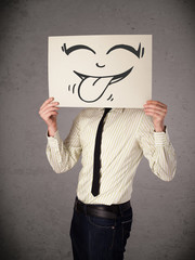 Wall Mural - Businessman holding a paper with funny smiley face in front of h