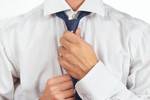 Guy Tying His Tie Over Bright Shirt Close Up