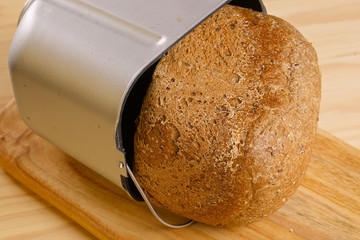 Fresh loaf of rye bread on wooden table