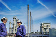 © christian42 - oil workers in front of large chemical refinery