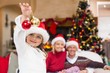 © WavebreakMediaMicro - Cute little girl wearing santa hat holding bauble
