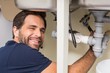 © WavebreakMediaMicro - Happy plumber fixing under the sink