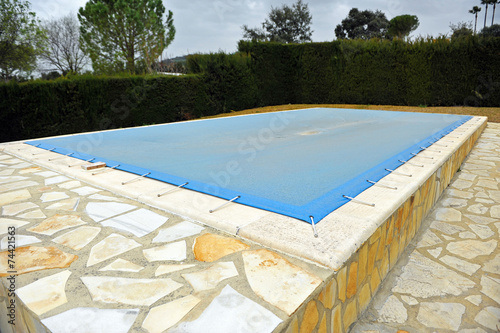 Fotografía Piscina protegida con una lona azul, invierno