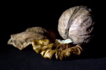 Wall Mural - Whole Walnut and a Cracked Walnut Isolated on Black Background