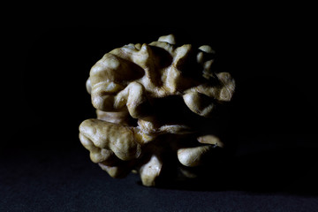 Wall Mural - Large Wrinkled Edible Seed of a Walnut Isolated on Black