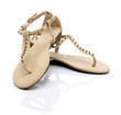 Beige sandals with studs on a white background