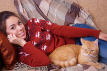 Young Woman Resting On Sofa With A Cat