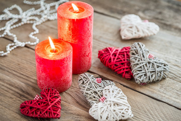 Wall Mural - Hearts with burning candles on the wooden background