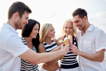 Canvas Print - smiling friends eating ice cream on beach