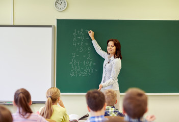 Canvas Print - school kids and teacher writing on chalkboard