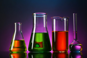 Test tubes with liquid on dark colorful background