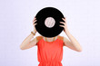 © Africa Studio - Young woman holding retro record in front of face,